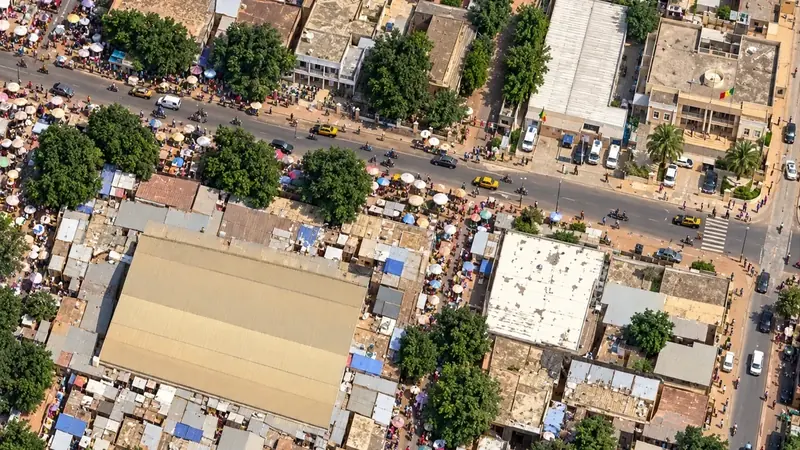 Le marché de Bambey vu du ciel, avec sa grande halle, ses étals et ses parasols